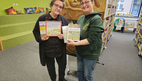 Ilona Wiese (AGU) überreicht vier Regenwurmbücher an Jasmin Arnold (Stadtbücherei)