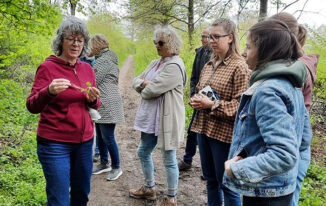 Dr. Britta Kuntz erläutert den Teilnehmern der Kräuterwanderung essbare Wildkräuter und deren Verwendungsmöglichkeiten in der Küche.